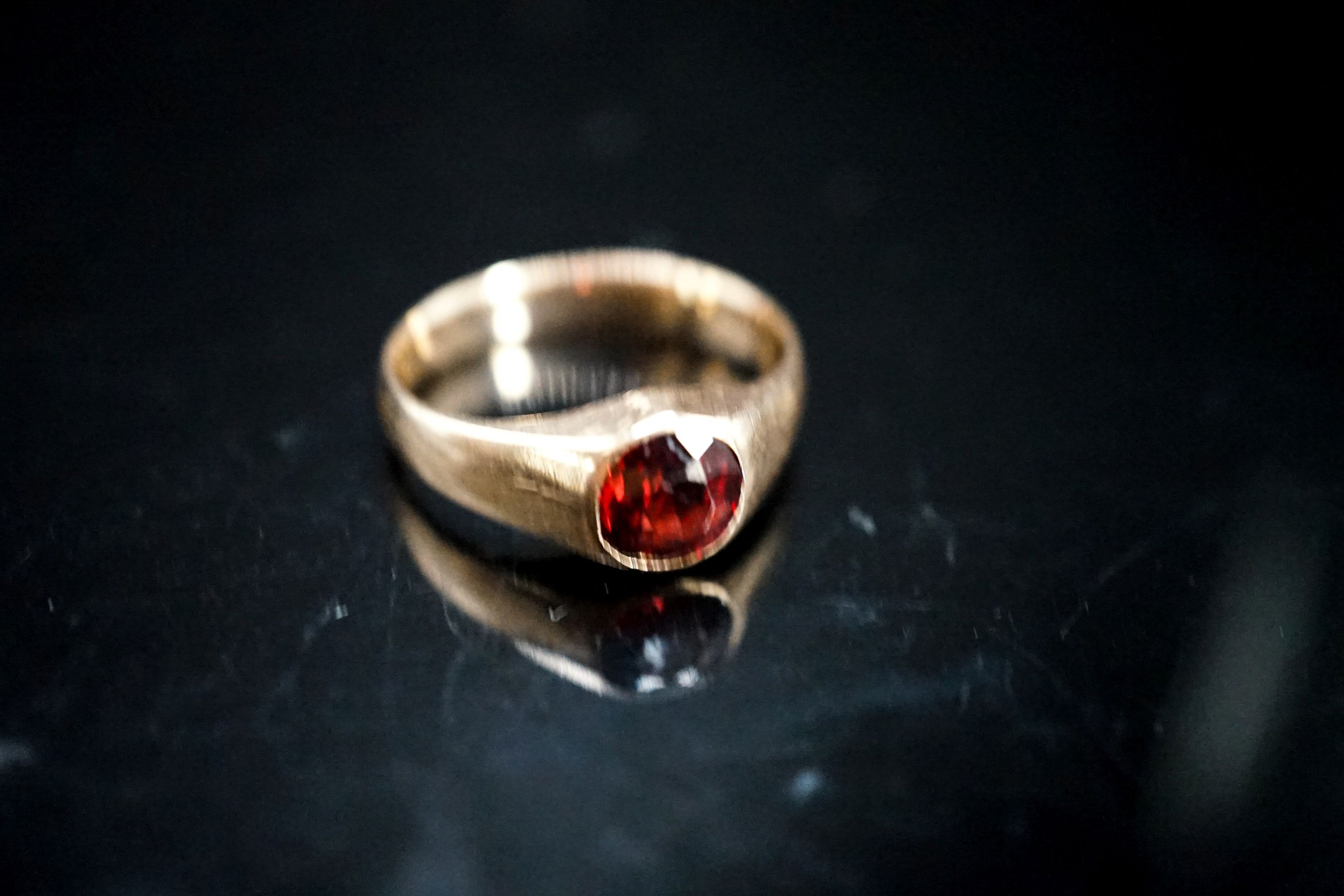 A yellow metal and garnet set ring, size N, gross 4.5 grams.